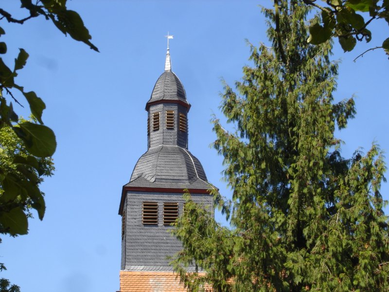 der Kirchturm vor blauem Himmel