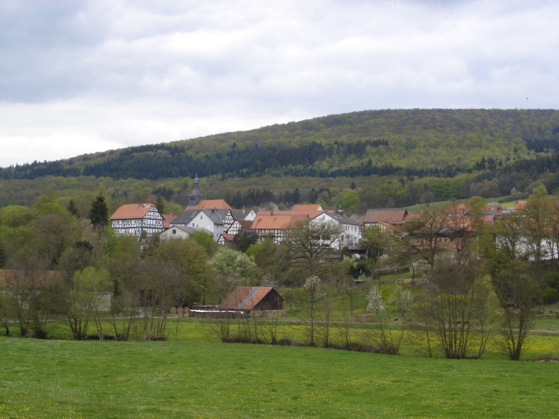 Das <em>Hinterdorf</em> von Densberg mit der Kirche und dem Pfarrhaus (ganz links), im Vordergrund das Tal der Gilsa