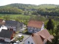 Pfarrhaus und evangelisches Gemeindehaus (rechts vorn) vom Kirchturm aus gesehen, im Hintergrund das Gilsatal und der Hemberg