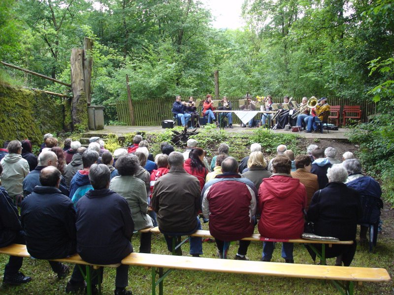 etwa 60 Besucher versammeln sich zum Gottesdienst unter freinem Himmel im Burggraben